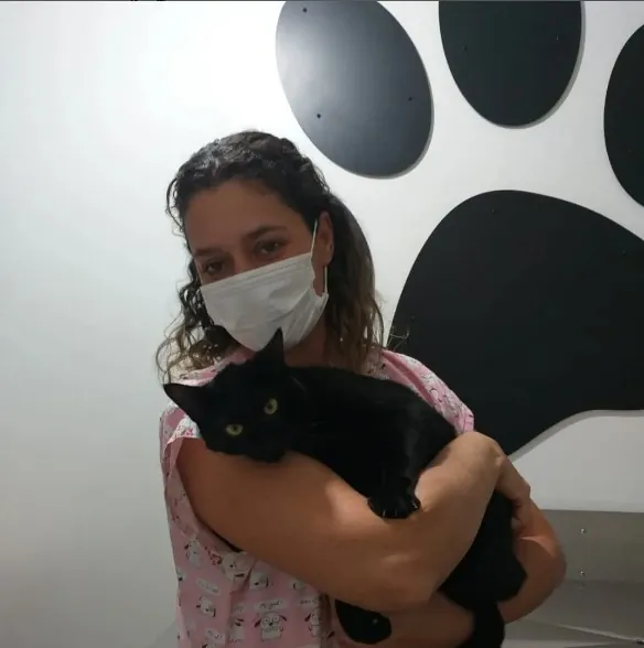 Veterinária segurando gato preto na Clínica Bom Jesus